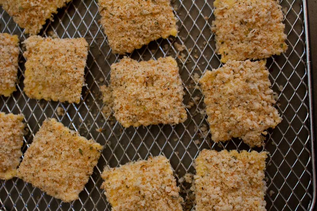 breaded ravioli spaced out on air fryer rack