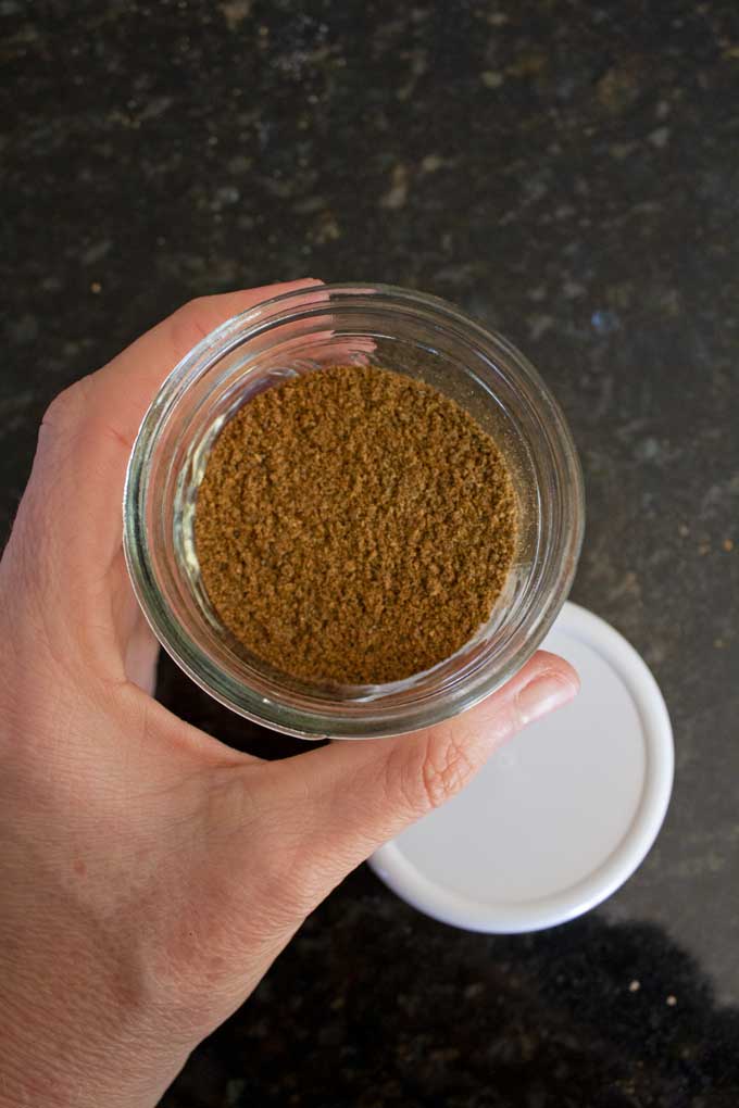 hand holding garam masala in jar