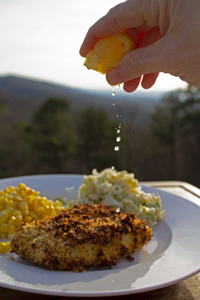 squeezing lemon over air fryer cod