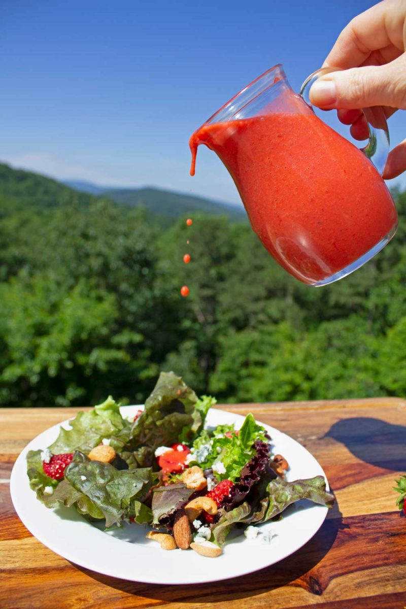 pouring dressing over salad with mountain view