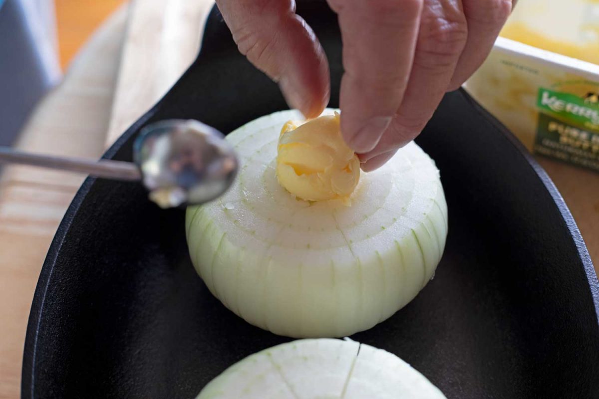 putting butter on cored onion