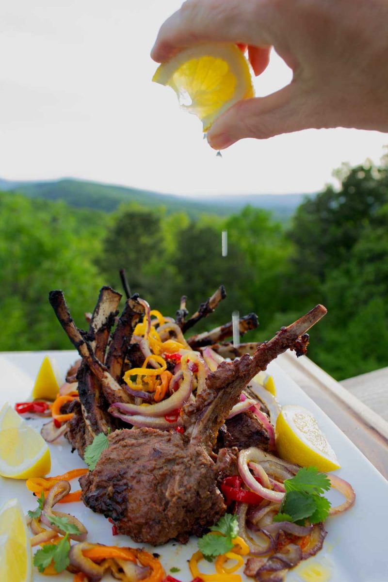 squeezing lemon juice over lamb chops