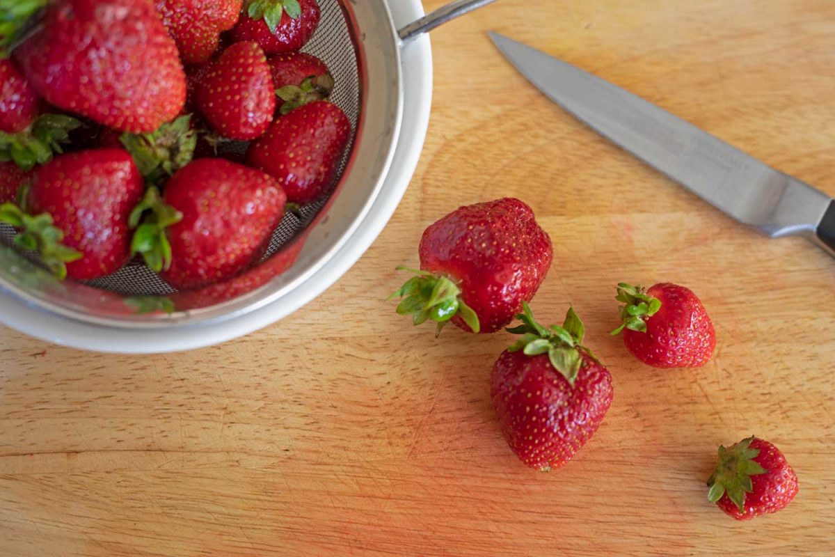 strawberries on cutting board with knife