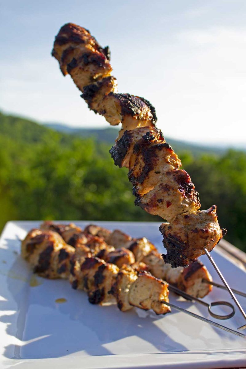 Greek Chicken Kabobs on plate with mountain view