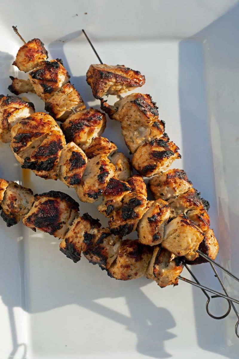grilled chicken kabobs stacked on platter
