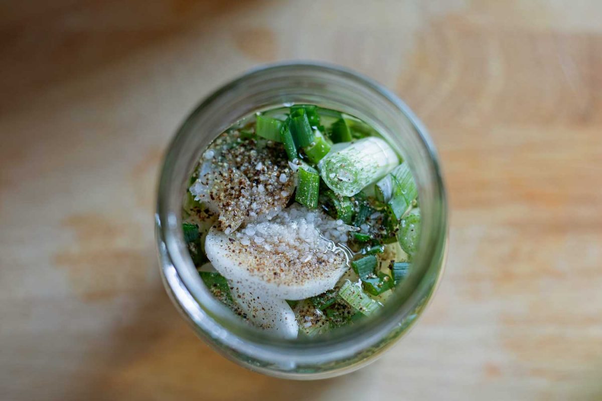 looking down into jar of spring onion vinegar