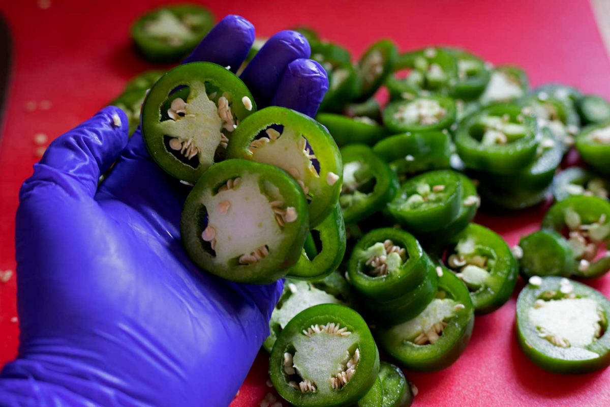gloved hand with jalapeno slices