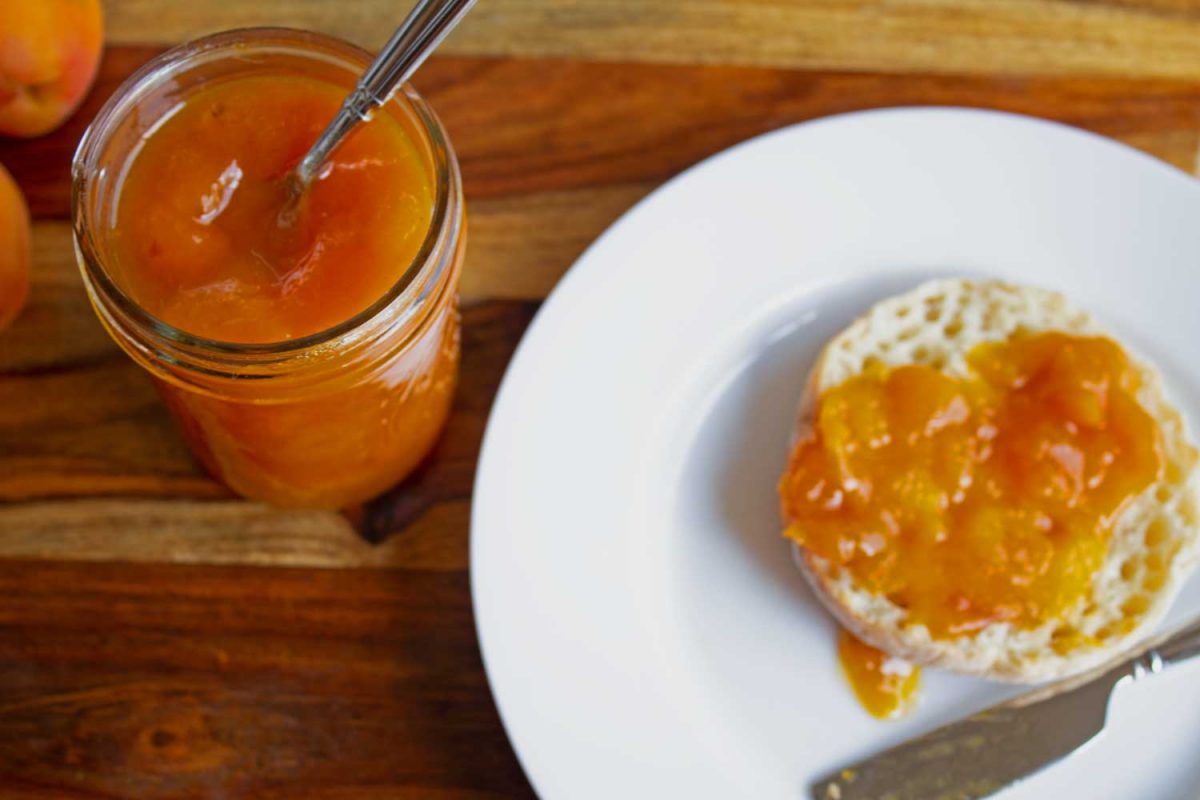 jar of apricot jam with toast on plate