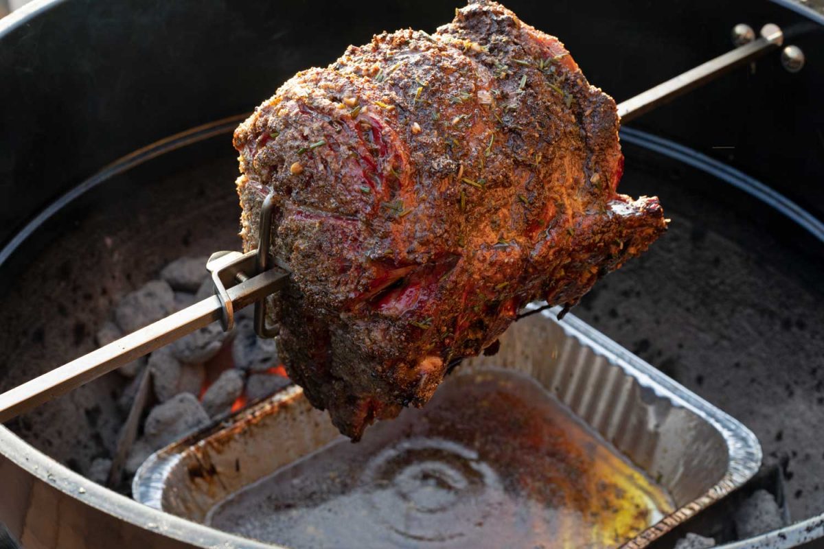 juicy beef dripping into pan below rotisserie