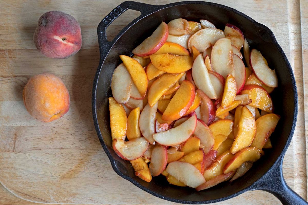 peach slices inside cast-iron skillet