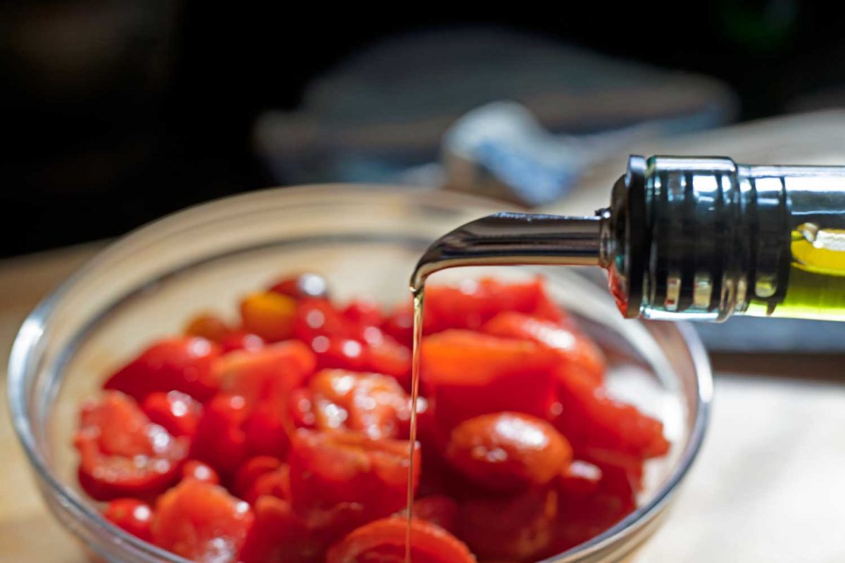 pouring olive oil over tomatoes