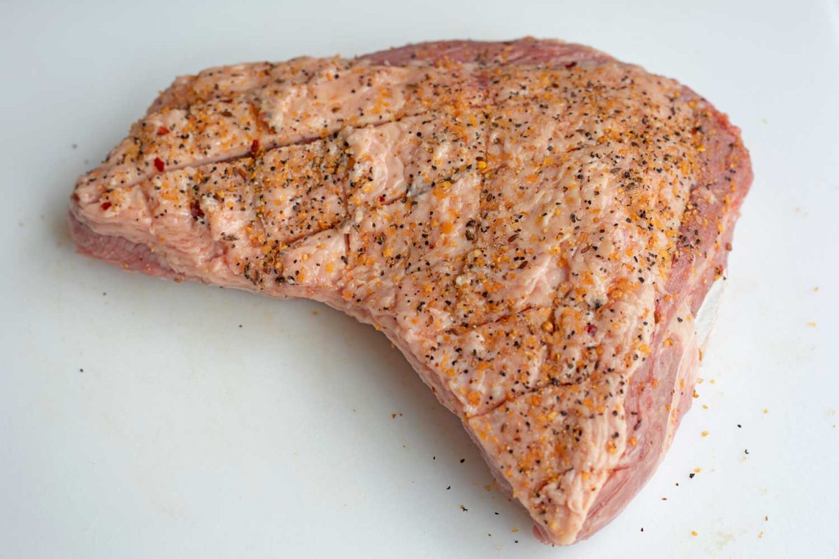 raw tri tip rubbed with seasoning on cutting board