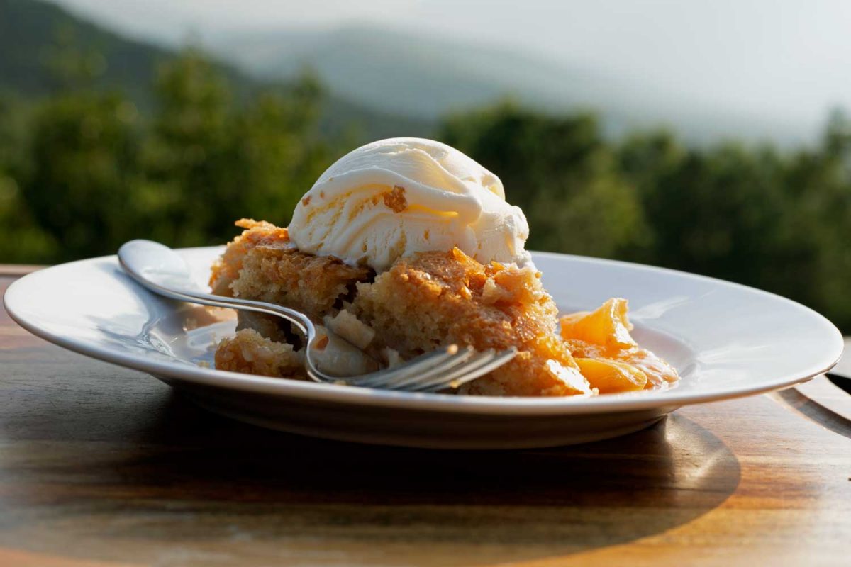 slice of peach skillet cake topped with ice cream with mountain view