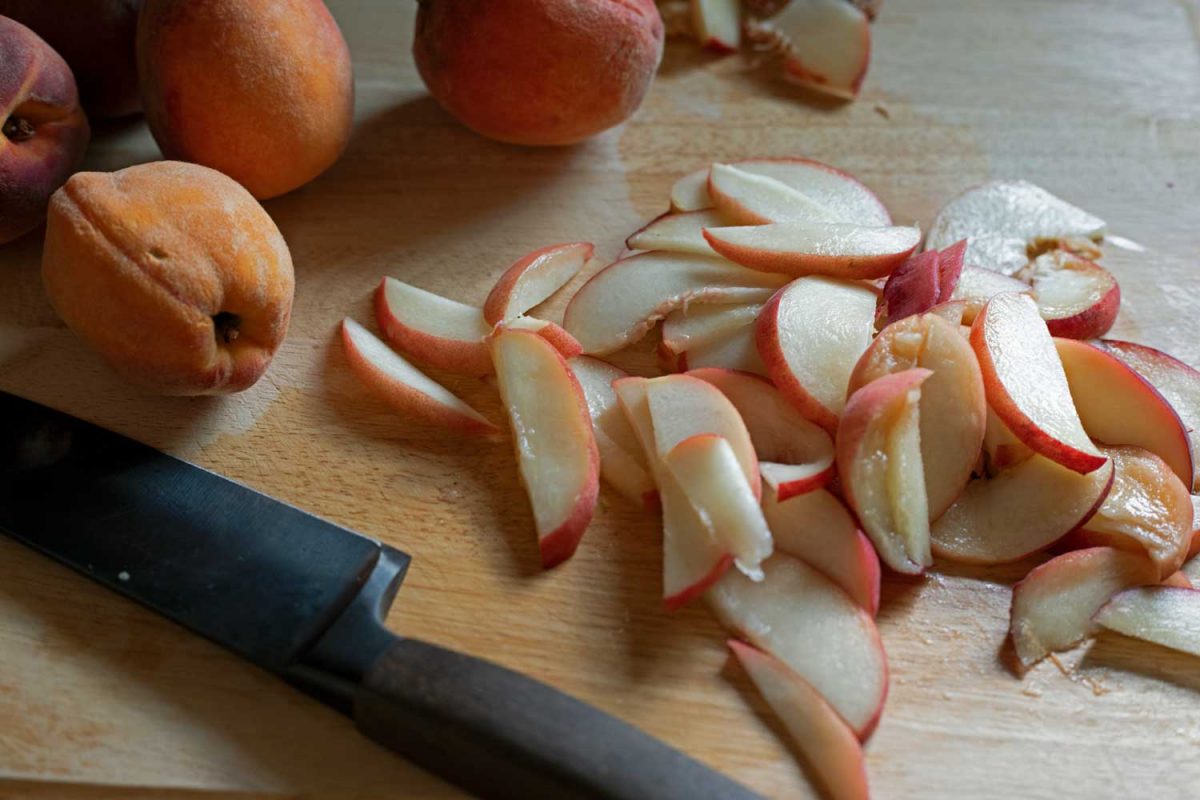 sliced peaches on cutting board
