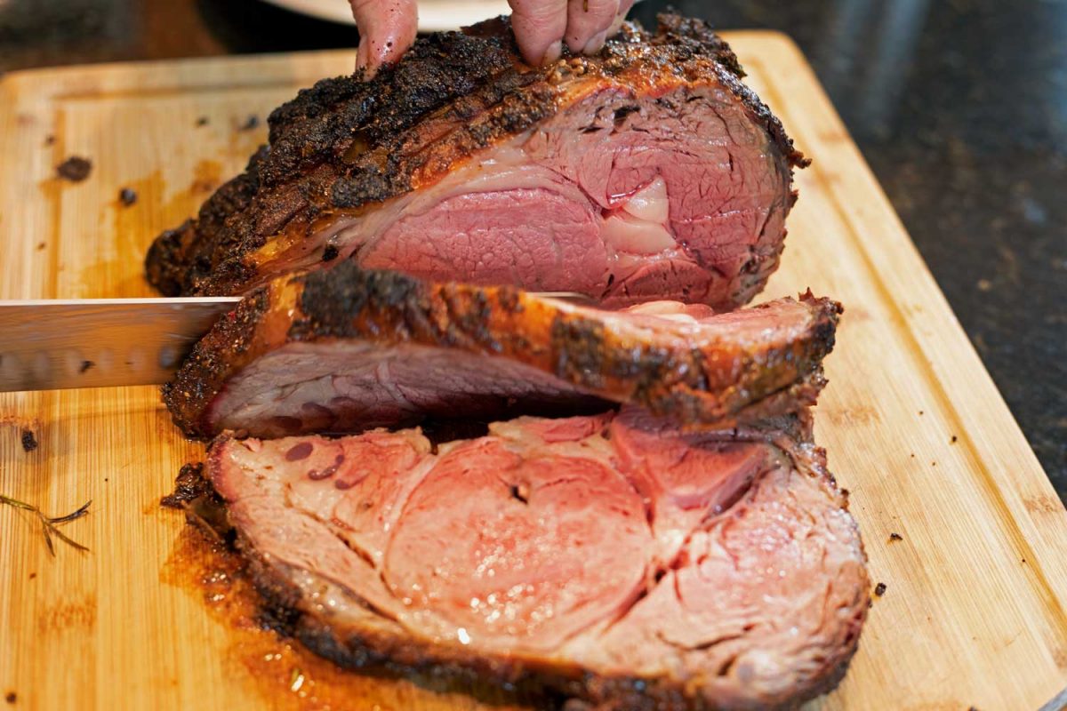 sliced standing prime rib roast on carving board