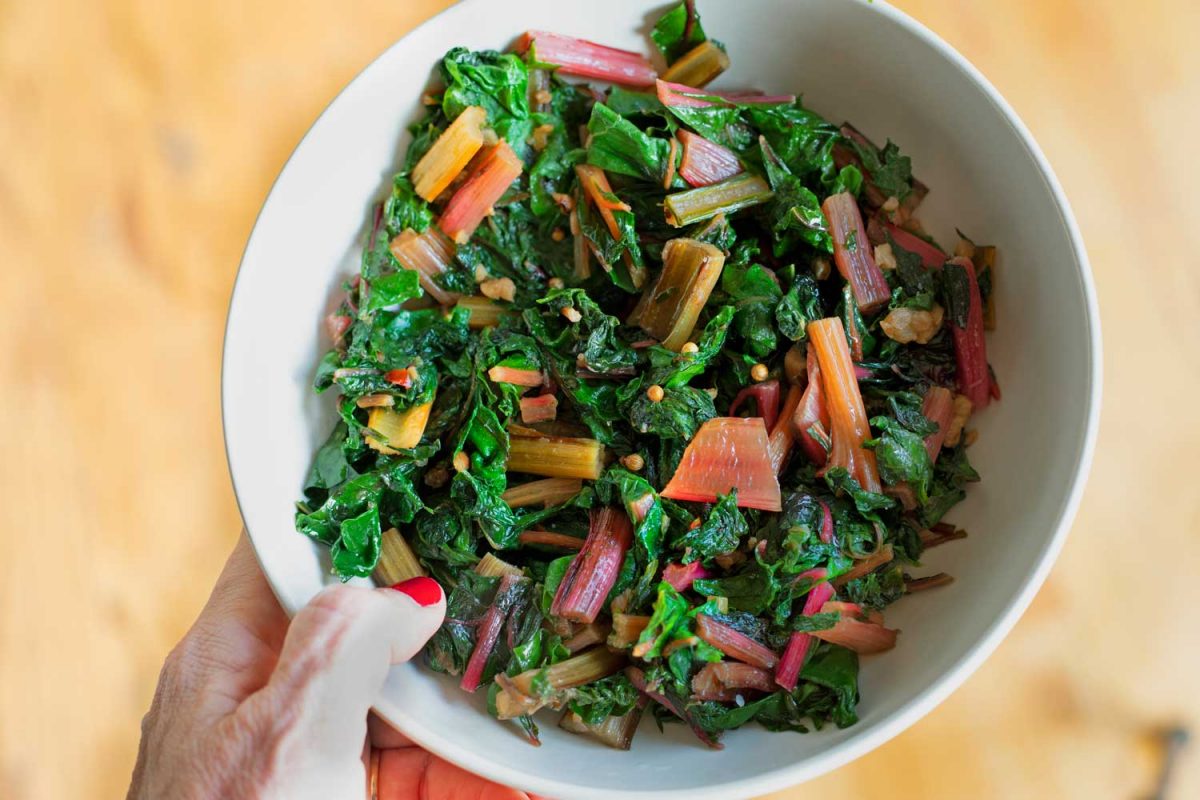 hand holding bowl of chard
