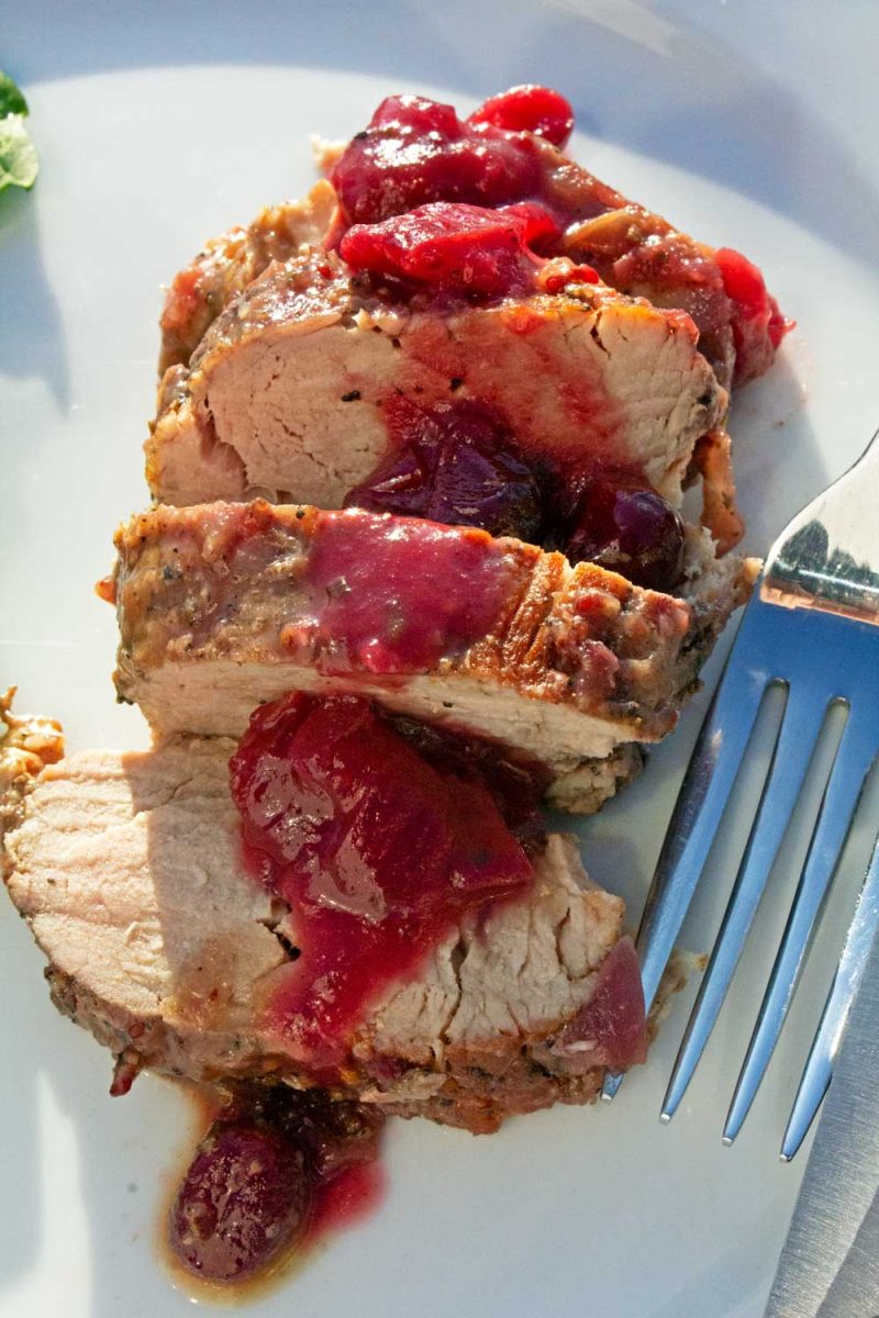 sliced pork tenderloin with cranberry sauce poured over
