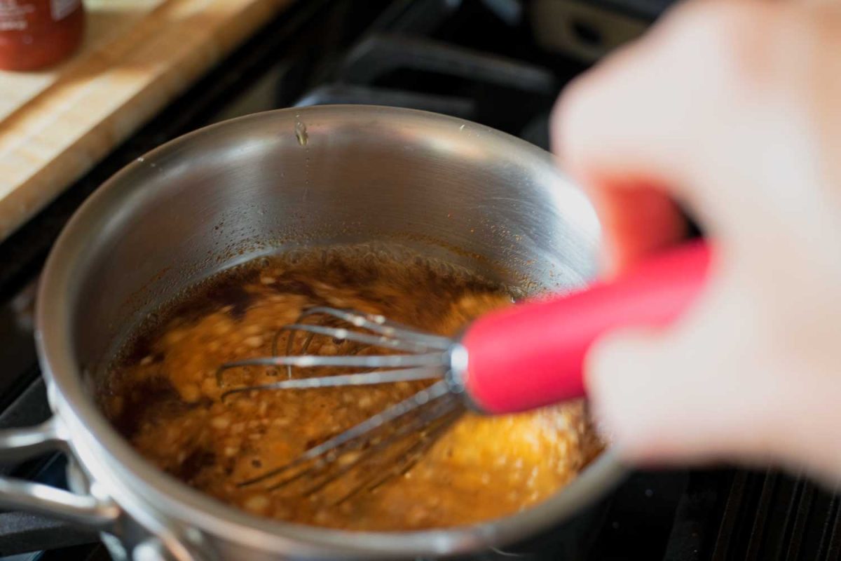 whisking sauce in saucepan