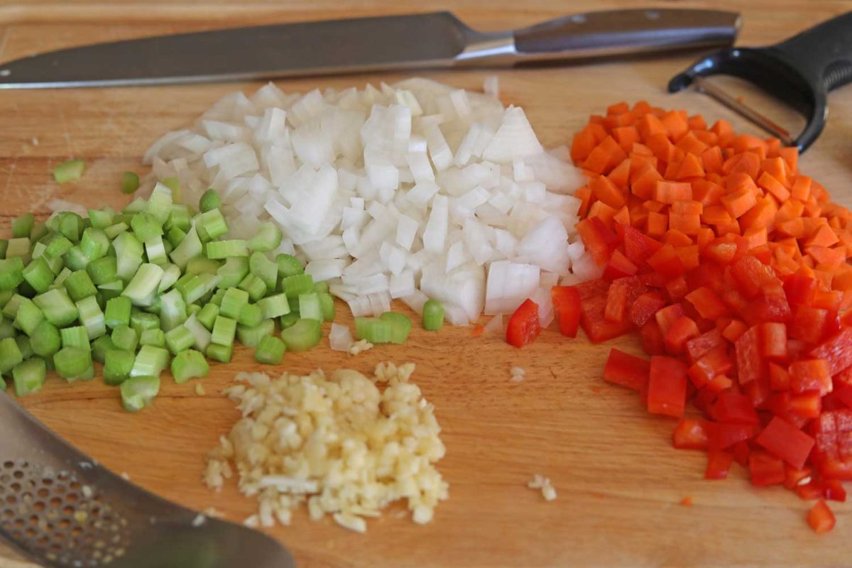 trinity of diced vegetables on cutting board