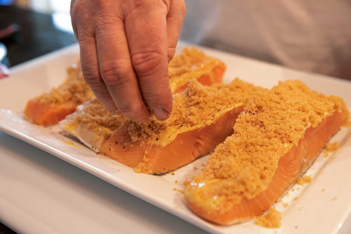 sprinkling brown sugar on salmon
