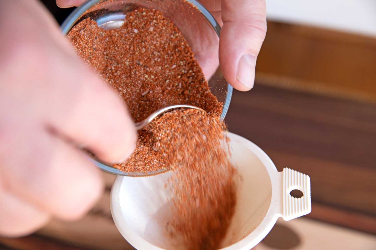 funneling pork dry rub into container
