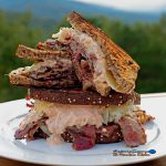 pastrami reuben sandwich stacked on plate