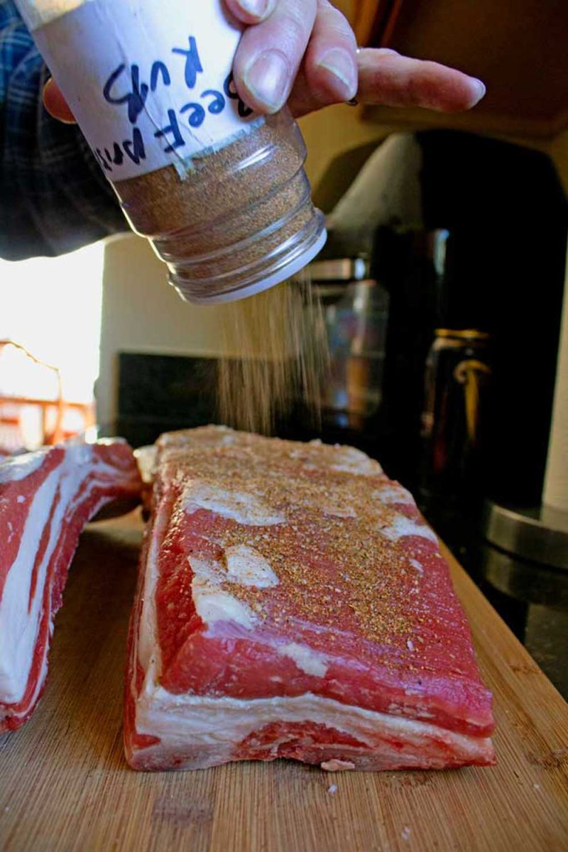 sprinkling rub onto beef