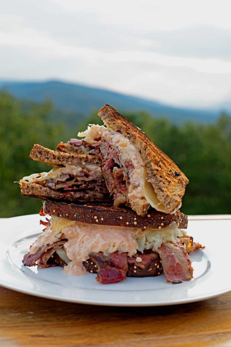 stacked pastrami reuben sandwich on plate
