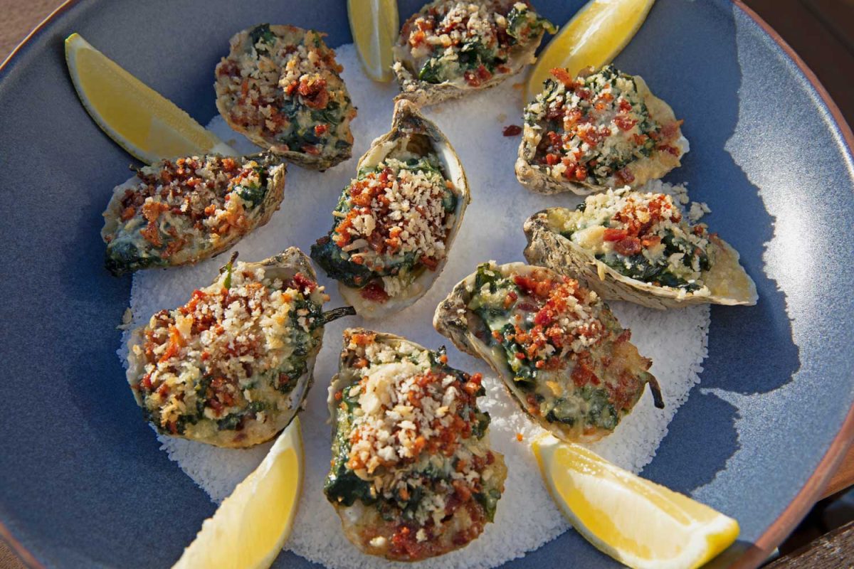grilled oysters rockefeller in a bowl of salt