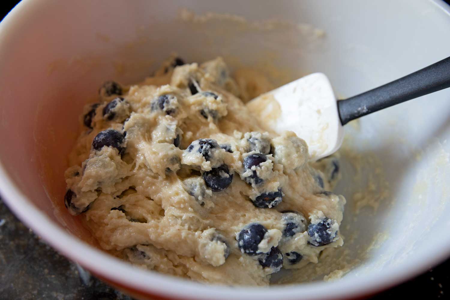 spatula folding blueberries into batter