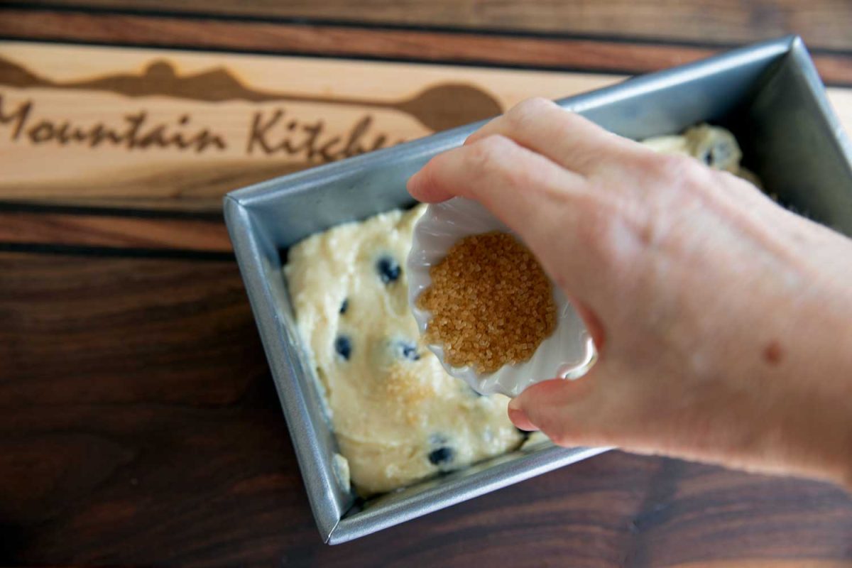 sprinkling turbinado sugar over bread batter