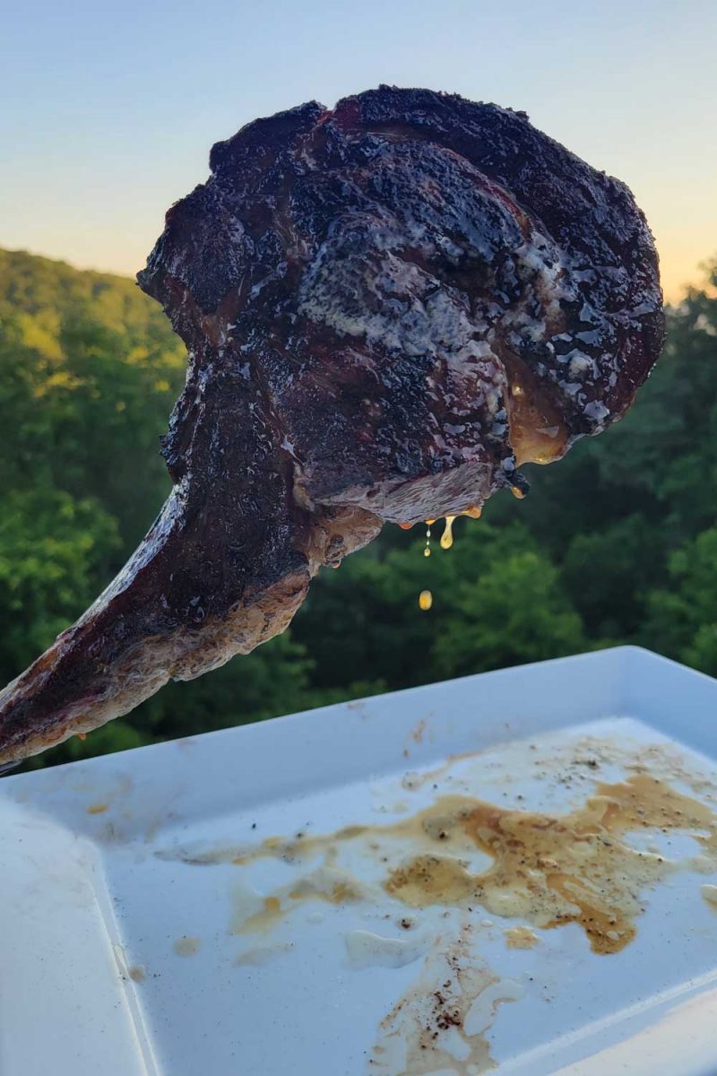 tomahawk steak dripping over plate