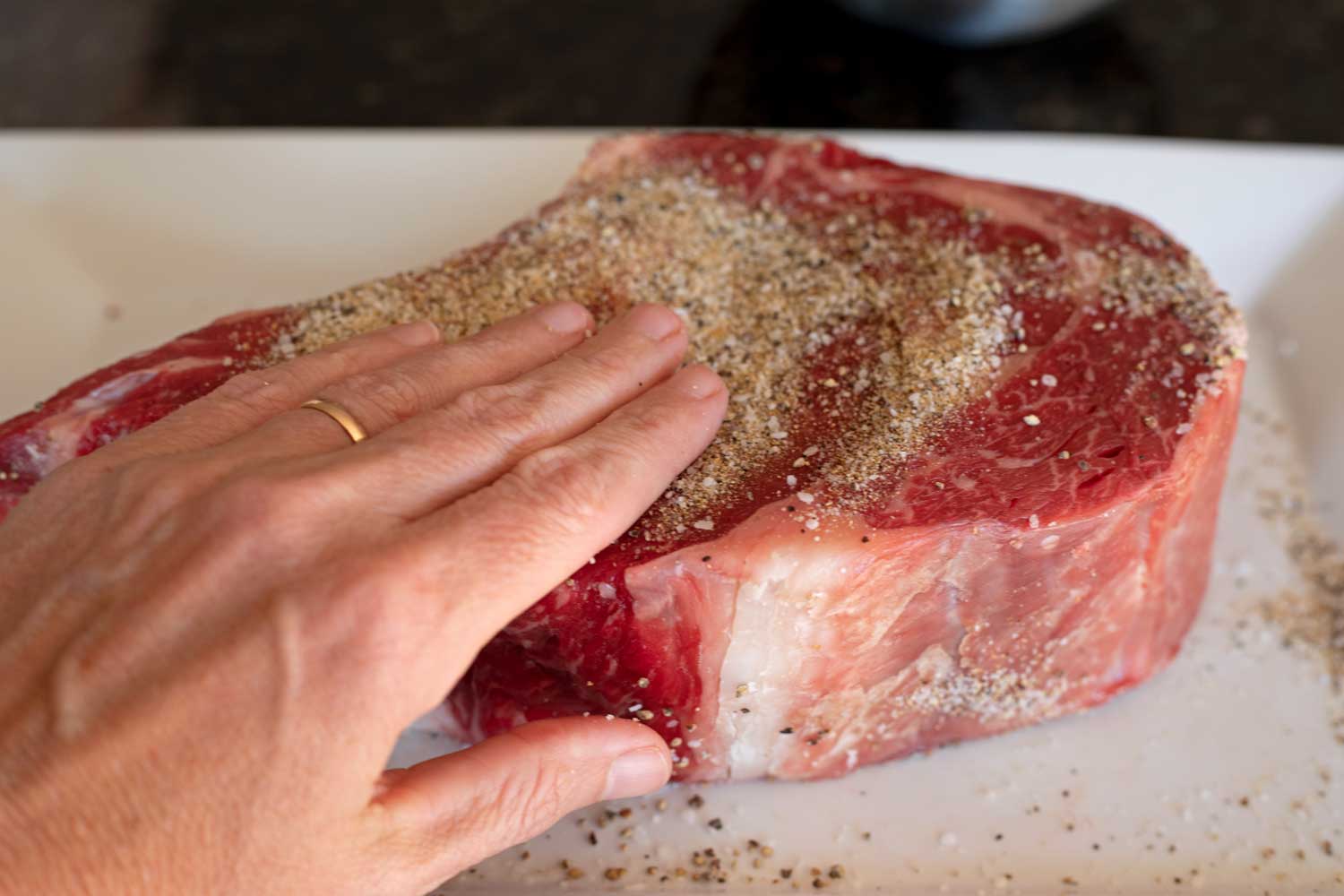 rubbing steak with salt pepper and garlic powder