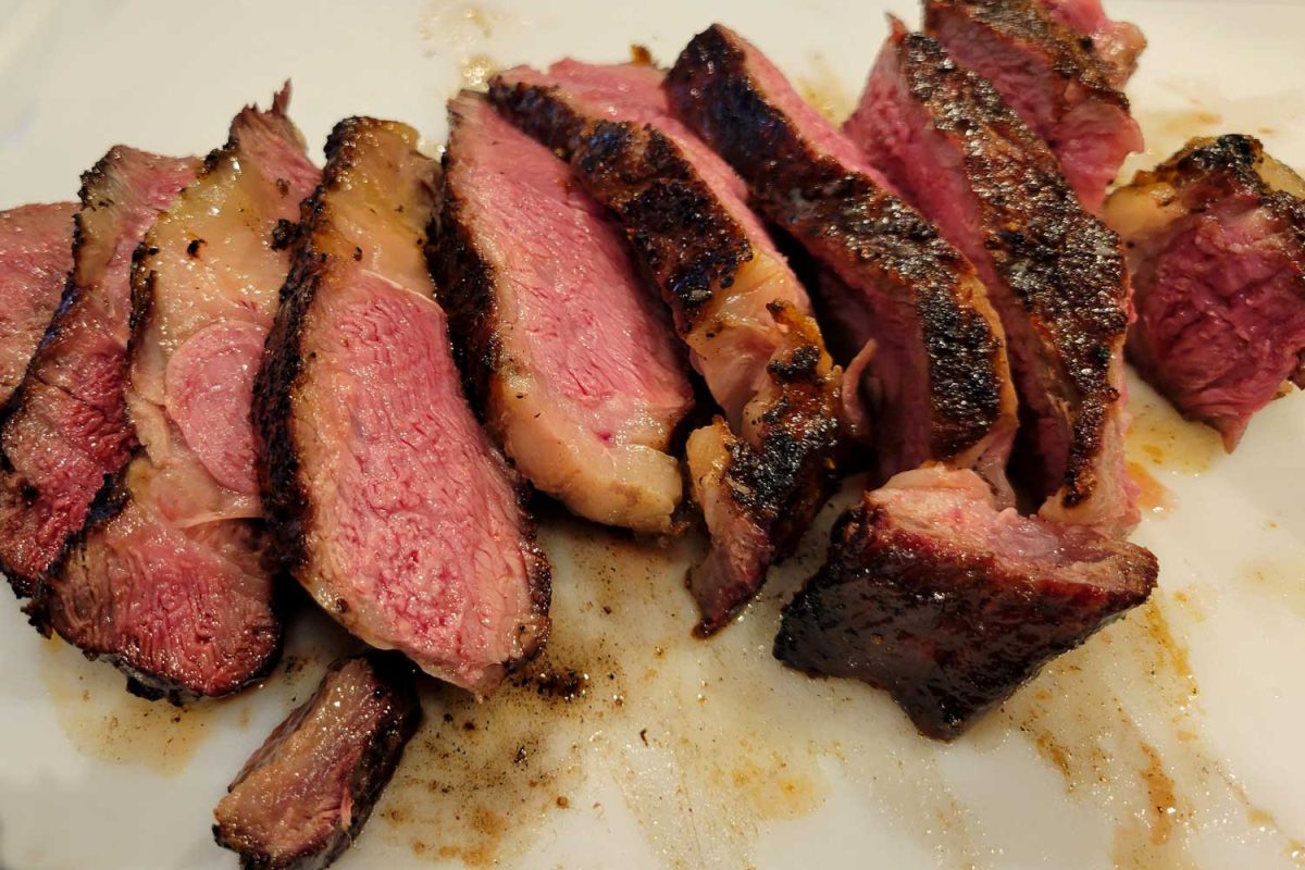 sliced tomahawk steak on cutting board