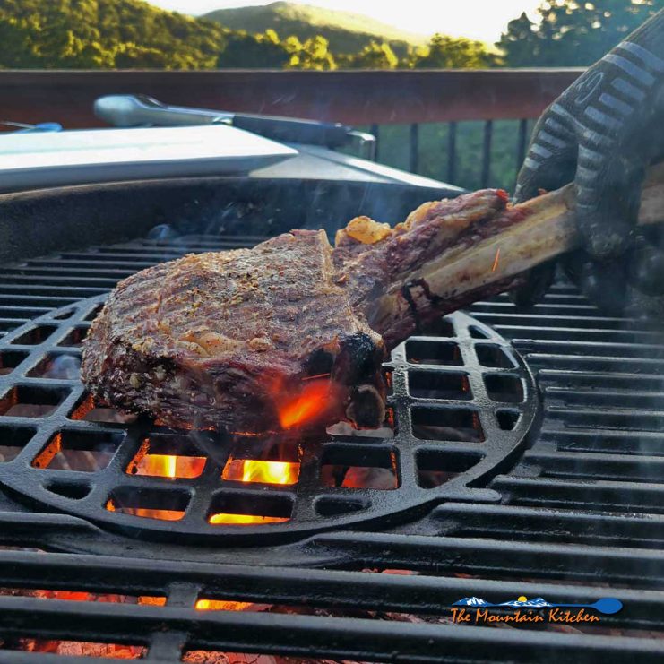 tomahawk steak searing on grill