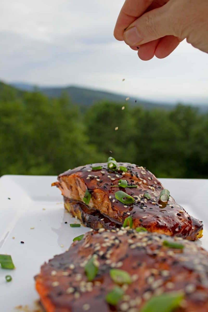 sprinkling sesame seeds onto pineapple grilled salmon