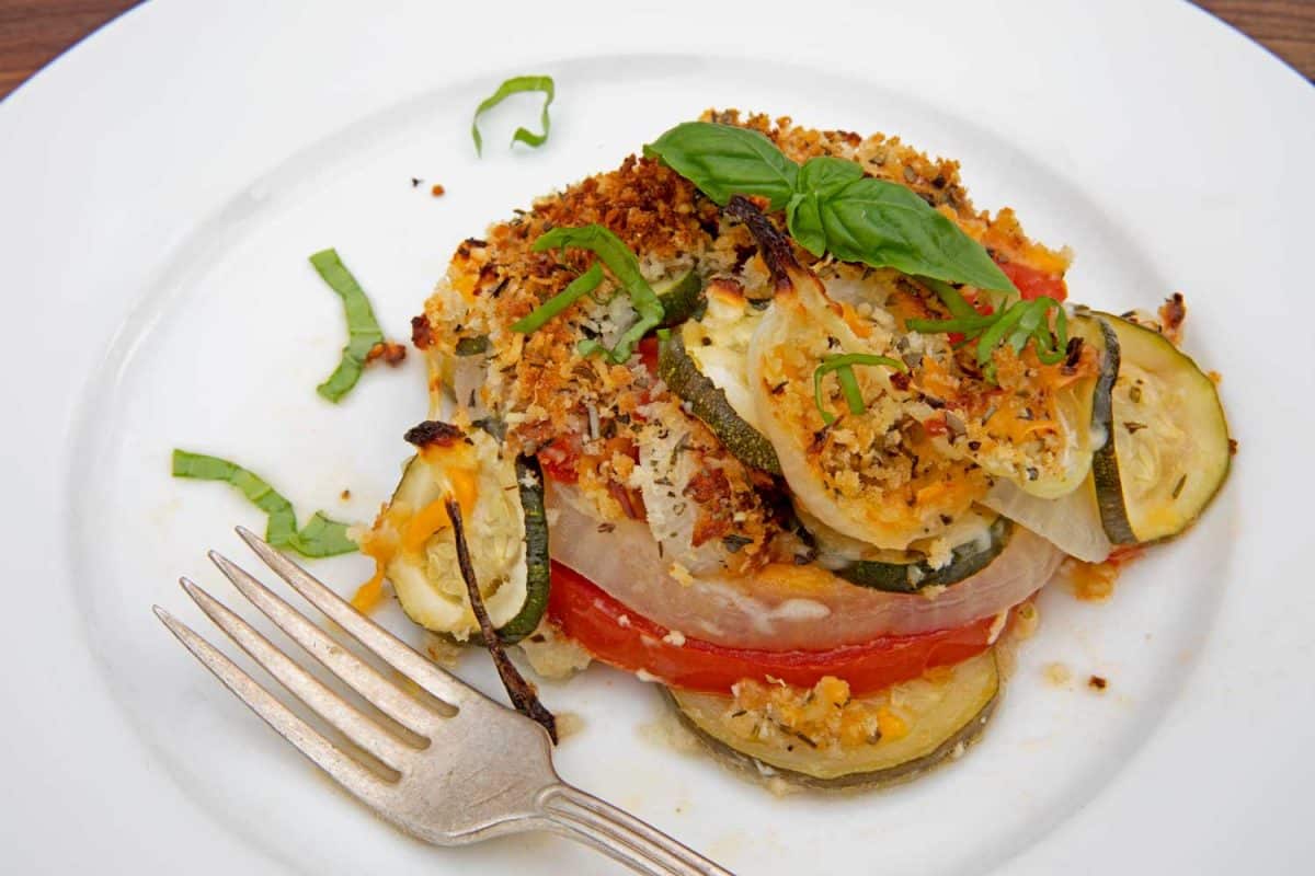 zucchini casserole served on plate garnished with basil