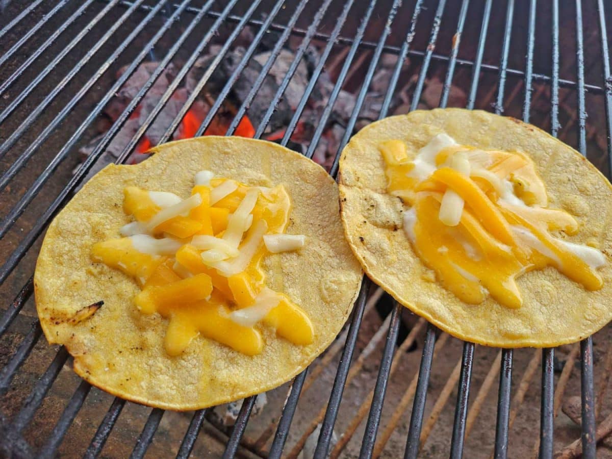 melting cheese on grilled corn tortillas