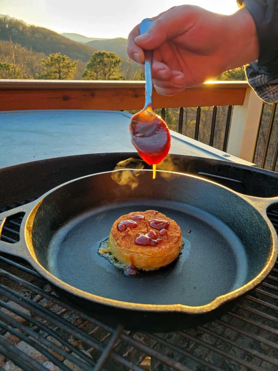 drizzling barbecue sauce over grilled brie