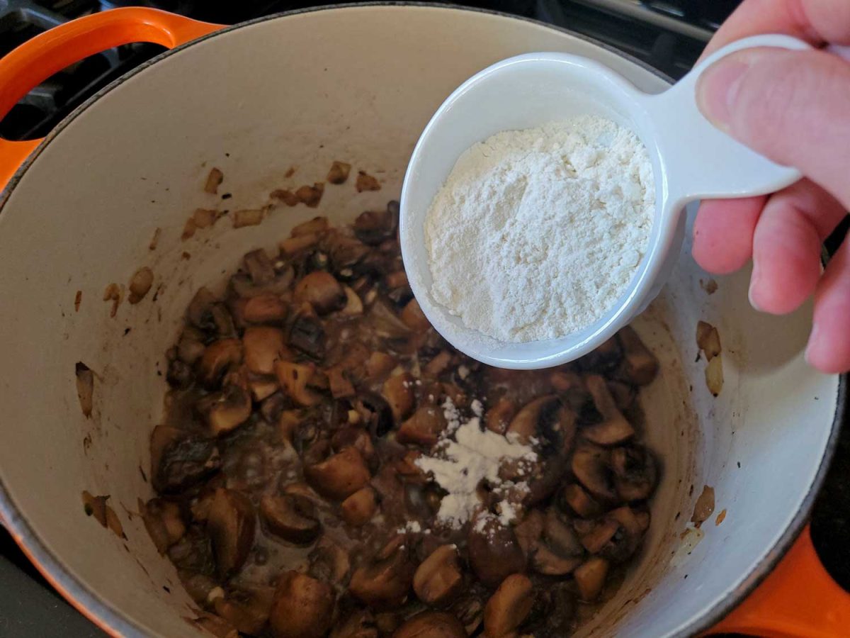 sprinkling flour into mushrooms