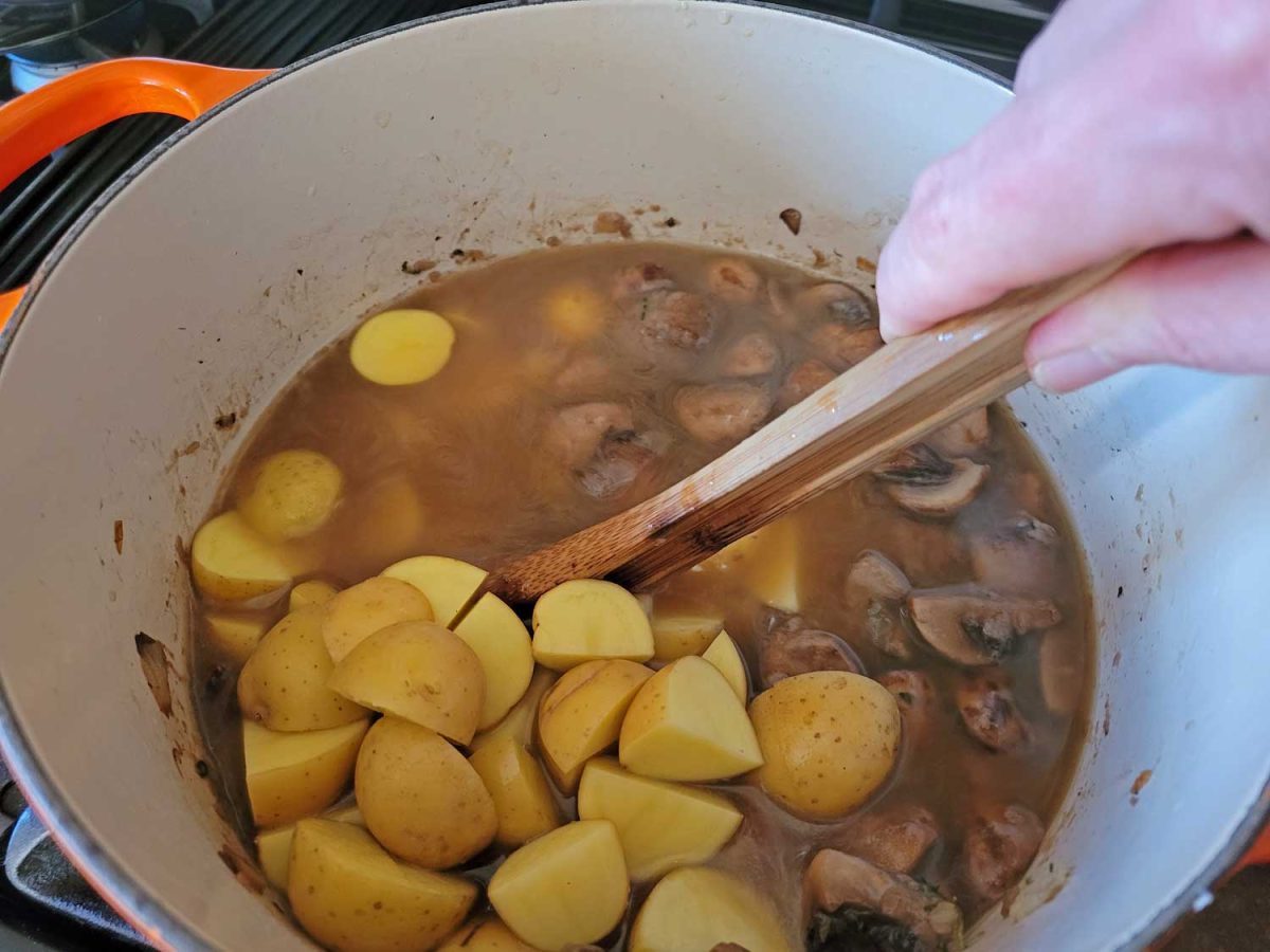 stirring potatoes into pot