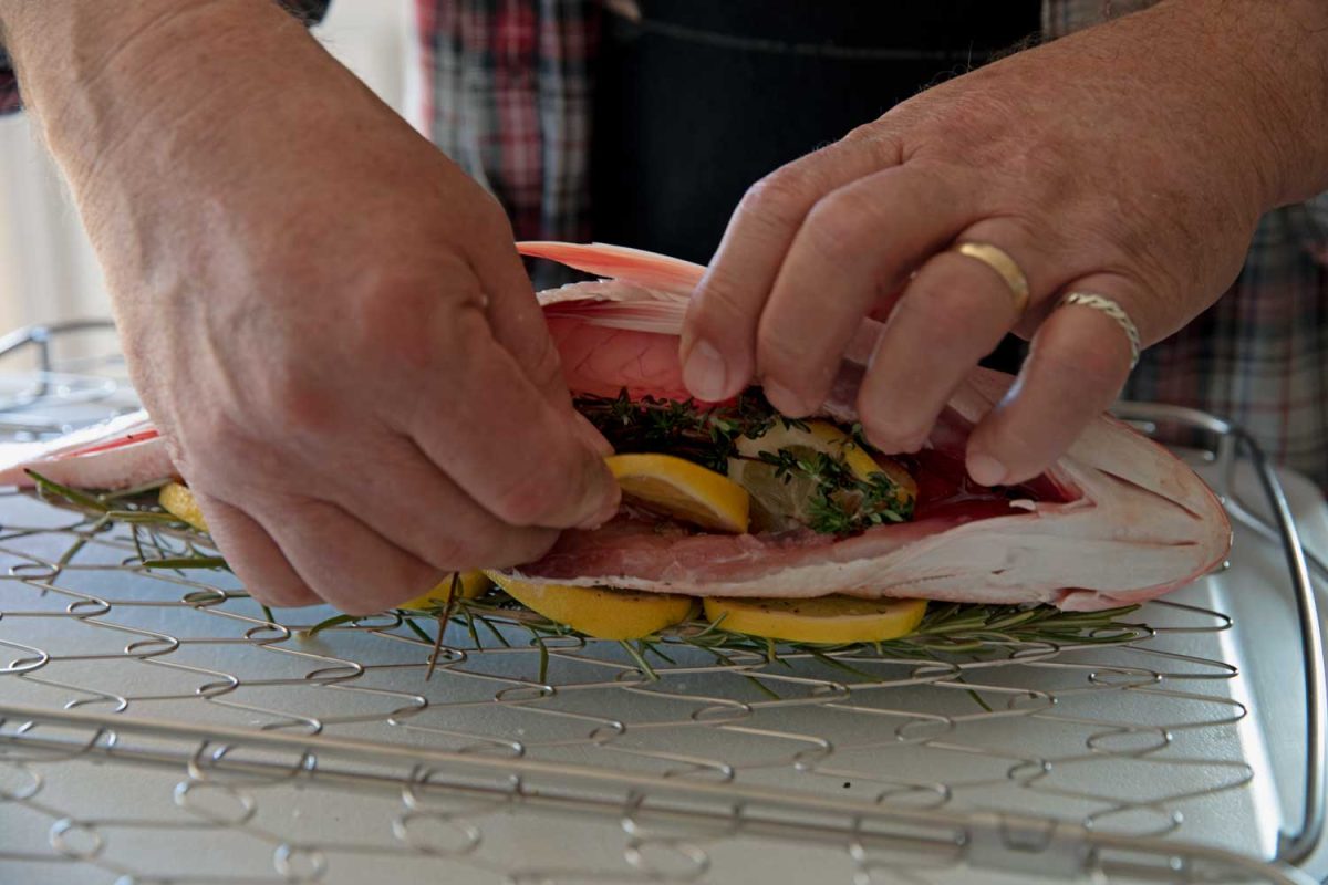 stuffing lemon and fresh herbs inside fish