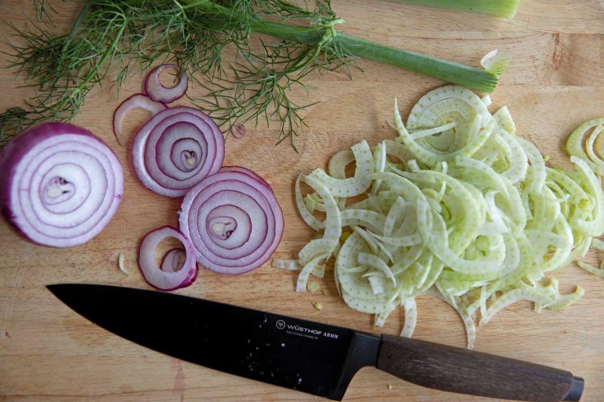sliced fennel and onion on cutting board for fennel orange salad