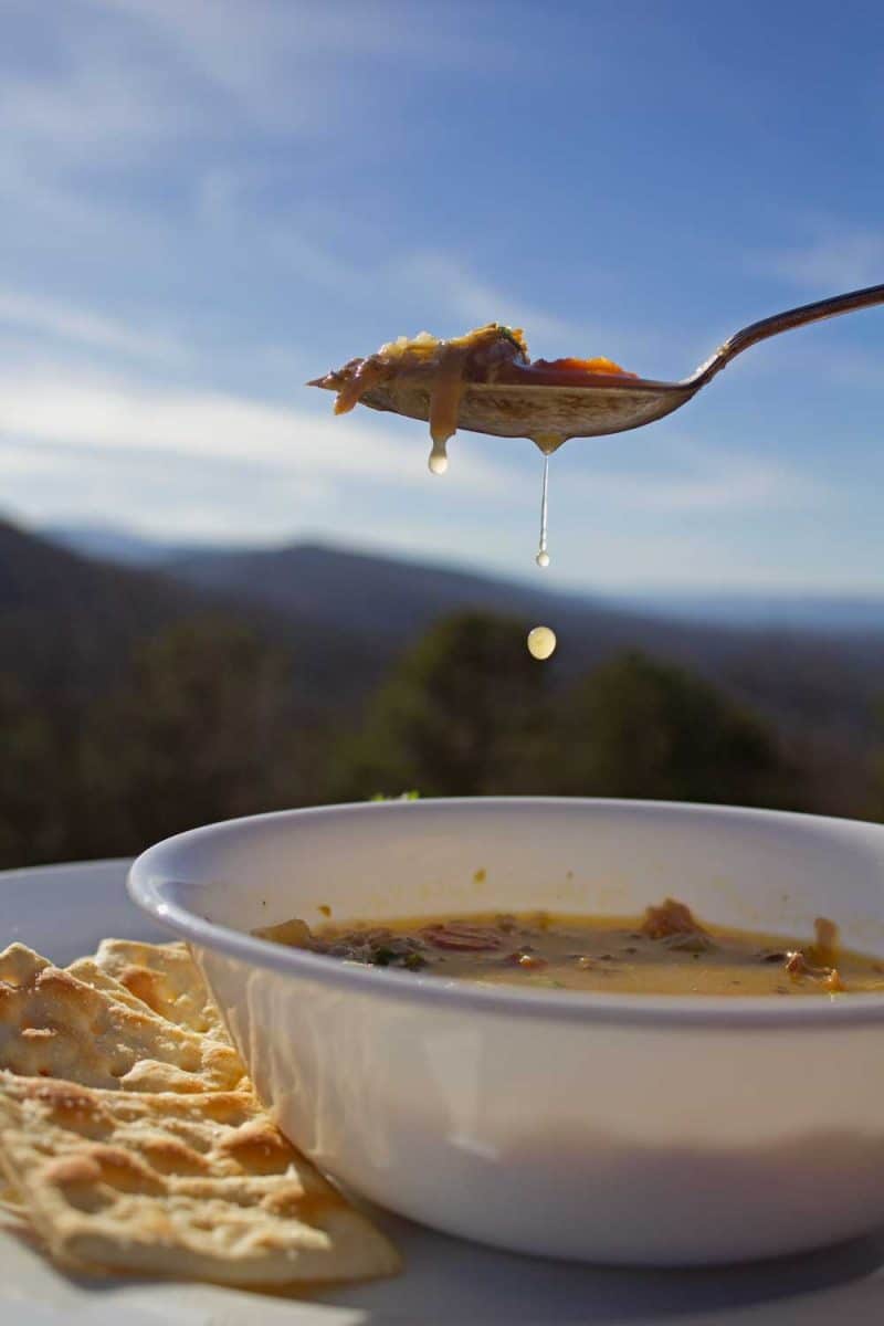 spoonful of shot turkey soup dripping over bowl