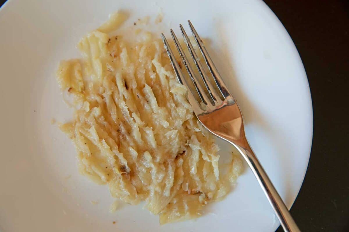 smashed garlic in plate with fork