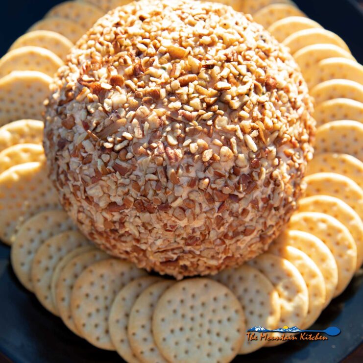 smoked cheese ball on plate with crackers