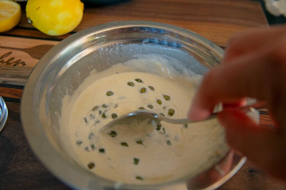 stirring capers into the sauce