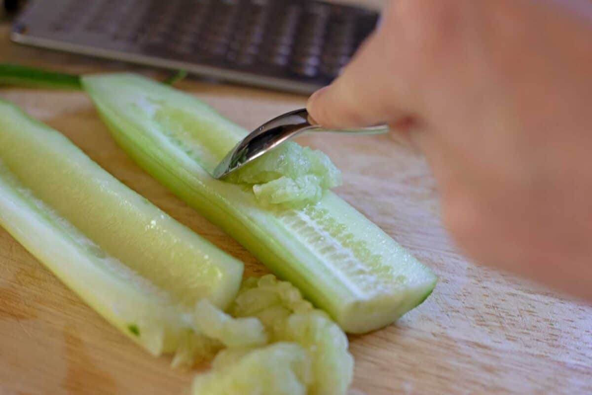 spoon removing seeds from cucumber