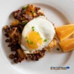 chorizo breakfast hash with fried egg and orange slices