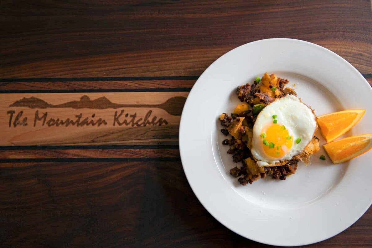 plate of chorizo breakfast hash with egg and orange slices